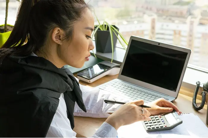 Professional reviewing financial documents with a calculator, representing accounting CPD courses and accountant continuing professional development.